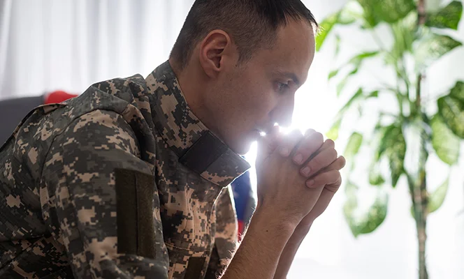 a man in military uniform with his hands together
