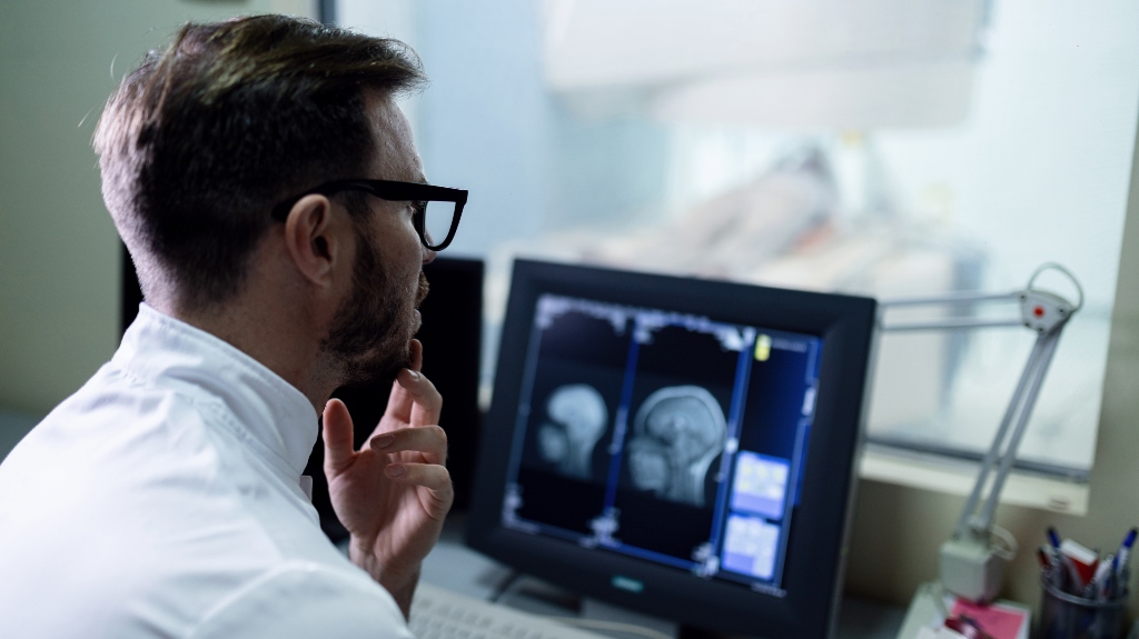 Doctor examining MRI scan results of a patient on the computer monitor