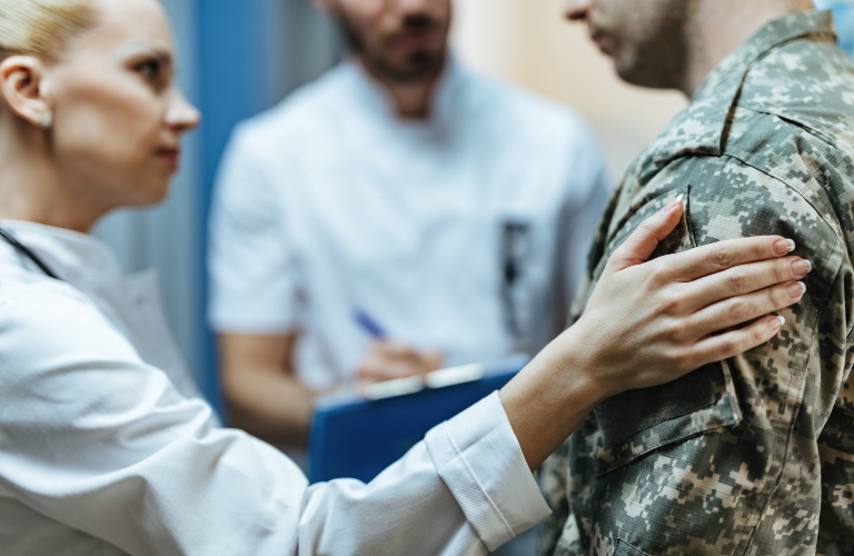 soldier being consoled by healthcare workers at clinic