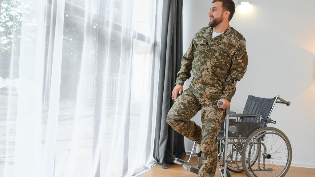 soldier in military uniform gets up from a wheelchair