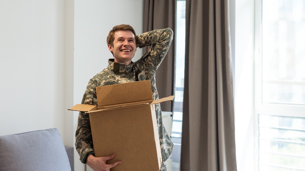 military man in uniform keeps box in new apartments