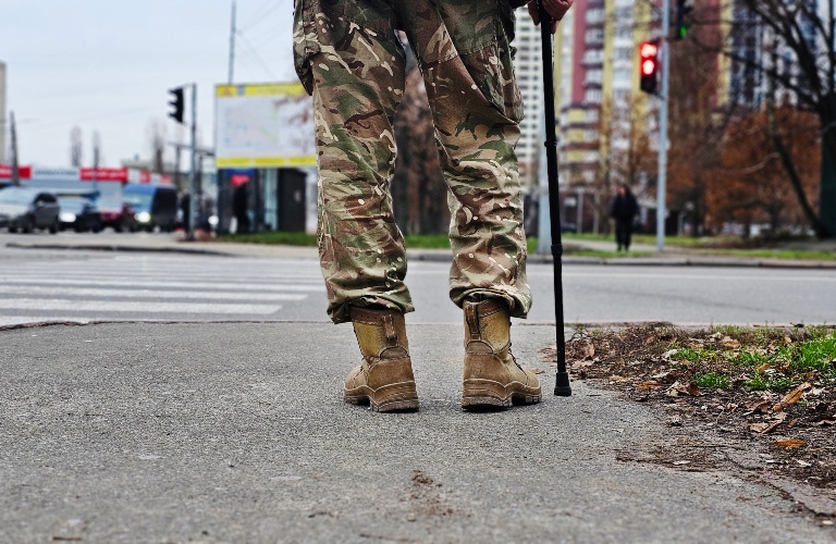Man in camouflage walking with crutches