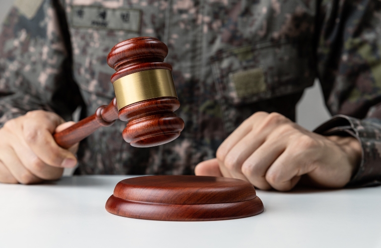 Military Law concept, Hand of soldier holding gavel at courtroom