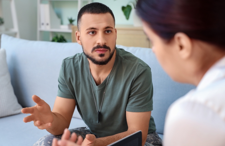 Young soldier with PTSD talking to psychologist in office